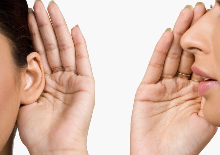 Close-up of a woman whispering into someone's ear